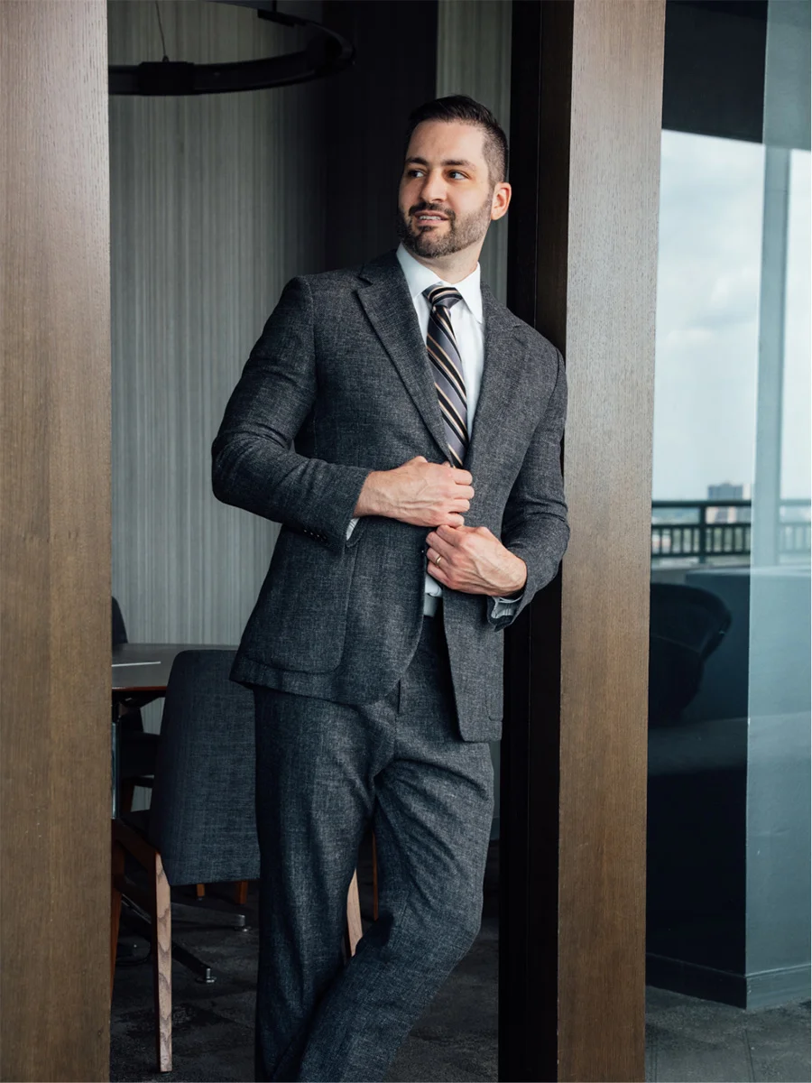 Doctor James Economides in charcoal suit standing confidently in modern medical office setting - Doctor in Chevy Chase, MD