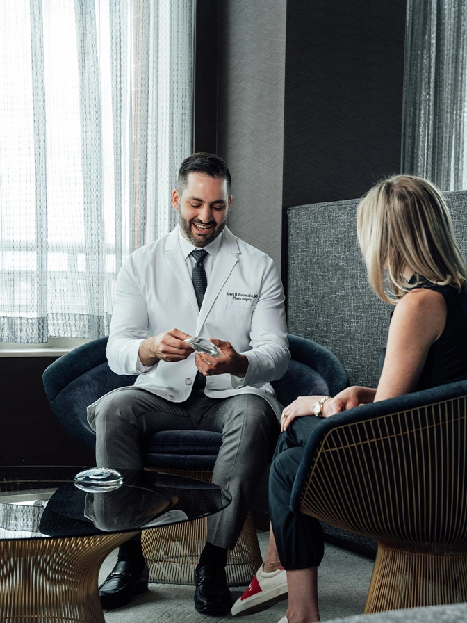 Dr James Economides meeting with female client in modern office setting - Breast augmentation in Chevy Chase, MD
