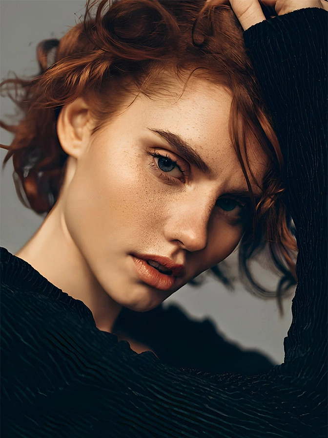 Red-haired woman with freckles in black clothing looking at camera with windswept hair and natural makeup - Brow lift in Chevy Chase, MD